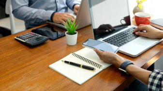 two-people-working-on-laptops-in-an-office-free-photo