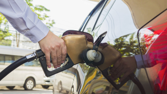 Man putting gasoline fuel into his car in a pump gas station